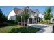 Elegant white brick home featuring a manicured front lawn, black fencing, and a convenient two-car garage at 2016 Thatcher Way, Fort Mill, SC 29715