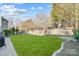Well-manicured backyard with a lush lawn, patio, and mature trees at 2024 Woodshorn Dr, Matthews, NC 28104