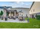 Well-maintained backyard with a patio featuring an outdoor kitchen, fireplace, and dining area at 2024 Woodshorn Dr, Matthews, NC 28104