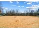 Community baseball field with a clay infield, bases, and backstop, providing a space for outdoor sports and recreation at 2024 Woodshorn Dr, Matthews, NC 28104