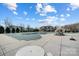 Community pool covered for the off-season, alongside a pool deck with lounge furniture, enhancing the community's appeal at 2024 Woodshorn Dr, Matthews, NC 28104