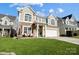 Charming two-story home featuring a stone facade, balcony, manicured lawn and an attached two car garage at 2024 Woodshorn Dr, Matthews, NC 28104