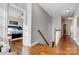 Upstairs hallway with wood floors and open bedroom with king bed at 2024 Woodshorn Dr, Matthews, NC 28104