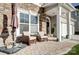 Cozy front porch with stone accents and comfortable seating for relaxing outdoors at 2024 Woodshorn Dr, Matthews, NC 28104