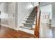 Carpeted staircase with wooden handrail leading to the second floor of the home at 2024 Woodshorn Dr, Matthews, NC 28104