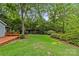 Lush backyard showcasing a wooden deck, expansive lawn, and mature trees at 2115 Laburnum Ave, Charlotte, NC 28205