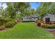 View of home and backyard featuring lush lawn, mature trees and deck area at 2115 Laburnum Ave, Charlotte, NC 28205