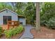 Backyard view features a shed, wooden deck, stone pathway, and mature trees at 2115 Laburnum Ave, Charlotte, NC 28205