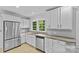 This kitchen offers stainless steel appliances, stone countertops, and white cabinetry, providing a modern culinary space at 2115 Laburnum Ave, Charlotte, NC 28205