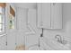 Bright laundry room with sink, washing machine, and storage space at 2115 Laburnum Ave, Charlotte, NC 28205