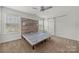 Bright bedroom with a wood accent wall, ceiling fan, and barn door to the bathroom at 225 Final Stretch Ln, Clover, SC 29710