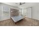 Bright bedroom with a wood accent wall, ceiling fan, and sliding barn door to the bathroom at 225 Final Stretch Ln, Clover, SC 29710
