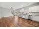 Open-concept kitchen with hardwood floors, white cabinets, stainless steel appliances, and granite countertops at 225 Final Stretch Ln, Clover, SC 29710