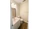 Well-lit bathroom features a mirror, single sink vanity, toilet and wood-look flooring at 2307 Hope Valley Ln, Charlotte, NC 28213