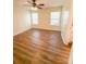 A cozy bedroom with wood-look flooring, two windows, and a ceiling fan at 2307 Hope Valley Ln, Charlotte, NC 28213