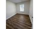 A well-lit bedroom with a window and wood-look flooring at 2307 Hope Valley Ln, Charlotte, NC 28213