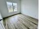 This bedroom features neutral walls, wood-look flooring, and a large, bright window at 2705 Eagle Dr, Lincolnton, NC 28092