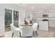 Cozy dining area featuring a round wooden table with white chairs, with view of the gray kitchen cabinets at 5156 Fireweed Ct, Dallas, NC 28034