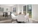 Bright dining area with a round wooden table, surrounded by chic white chairs and a sliding door to the outdoor deck at 5156 Fireweed Ct, Dallas, NC 28034