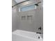 Well-lit bathtub and shower combination with gray subway tile, complemented by sleek black fixtures and recessed niches at 600 Campus St, Charlotte, NC 28216
