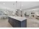 Open floor plan with kitchen featuring navy cabinets, quartz countertops, stainless appliances, and wood flooring at 600 Campus St, Charlotte, NC 28216