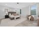 Main bedroom featuring a king bed, soft neutral colors, and a bright seating area at 600 Campus St, Charlotte, NC 28216