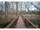 Picturesque backyard with a wooden bridge leading towards a beautiful home at 7210 Timber Ridge Dr, Mint Hill, NC 28227