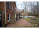 Brick patio and steps leading to backyard with in-ground pool and mature trees at 7210 Timber Ridge Dr, Mint Hill, NC 28227