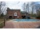 Red brick home featuring an in-ground covered pool, wooden deck, patio and a swing creating an outdoor oasis at 7210 Timber Ridge Dr, Mint Hill, NC 28227