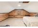 Charming attic bedroom with natural wood walls, plush carpet, and a cozy window view at 7210 Timber Ridge Dr, Mint Hill, NC 28227