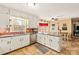 Bright kitchen with white cabinets, stainless steel appliances, and a view to the breakfast nook at 7210 Timber Ridge Dr, Mint Hill, NC 28227
