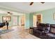 Open-concept living room with tile floors, a leather sofa, and easy access to other living spaces at 7210 Timber Ridge Dr, Mint Hill, NC 28227