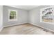 Bedroom with light grey walls and light colored hardwood flooring and two windows at 723 Wood St, Statesville, NC 28677