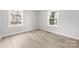 Bedroom with light grey walls and light colored hardwood flooring and two windows at 723 Wood St, Statesville, NC 28677