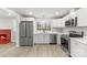 Updated kitchen with stainless steel appliances and white cabinetry next to living area at 723 Wood St, Statesville, NC 28677