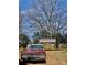 Classic car and storage building featured in the backyard underneath a large tree at 8508 Colgate Cir, Charlotte, NC 28214
