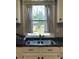 A kitchen sink next to a window looking out to the back yard and shed at 8508 Colgate Cir, Charlotte, NC 28214
