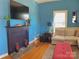 Warm living room featuring a fireplace, flat-screen TV, comfortable seating, and a bright window at 8508 Colgate Cir, Charlotte, NC 28214