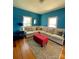 Cozy living room with blue walls, fireplace, white sofa, area rug and natural light from two windows at 8508 Colgate Cir, Charlotte, NC 28214