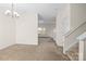 Open concept living room with neutral carpeting leading to open spaces, and a staircase at 8583 Carolina Lily Ln, Charlotte, NC 28262