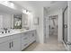 Bright bathroom featuring double vanity, granite counters, and a glass-enclosed shower with a spacious walk-in closet at 889 Regulus Ct, York, SC 29745