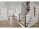 Bright hallway with wood flooring leading to a staircase and various rooms, enhanced by mirrors and console tables at 889 Regulus Ct, York, SC 29745