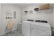 Well-organized laundry room with modern washer, dryer, decorative tile flooring and organized shelving at 889 Regulus Ct, York, SC 29745