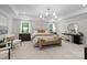 Spacious primary bedroom featuring a sitting area, tray ceilings, and ample natural light from large windows at 889 Regulus Ct, York, SC 29745