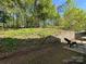 Picturesque backyard featuring a retaining wall and lush, mature trees providing privacy at 9031 Pembroke Ct, Indian Land, SC 29707