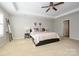 Bright bedroom features neutral walls, carpet, ceiling fan, and large window, creating a comfortable living space at 9031 Pembroke Ct, Indian Land, SC 29707