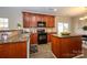 Functional kitchen with stainless steel sink, granite counters, island, and abundant wooden cabinets at 9031 Pembroke Ct, Indian Land, SC 29707
