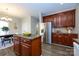 Kitchen island with granite countertop, dining area, and stainless steel refrigerator at 9031 Pembroke Ct, Indian Land, SC 29707