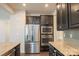 Stylish kitchen with stainless steel appliances, dark cabinets, granite countertops, and a large refrigerator at 10036 Paper Birch Dr, Charlotte, NC 28215