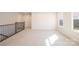 Spacious loft area with neutral carpeting, a wrought iron railing, and natural light at 10036 Paper Birch Dr, Charlotte, NC 28215